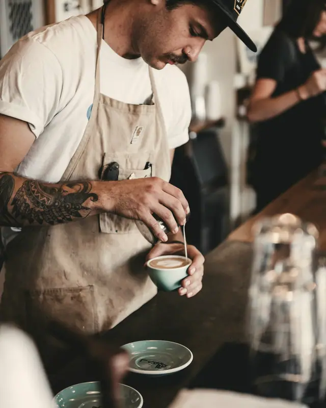 A barista preparing a coffee by hand