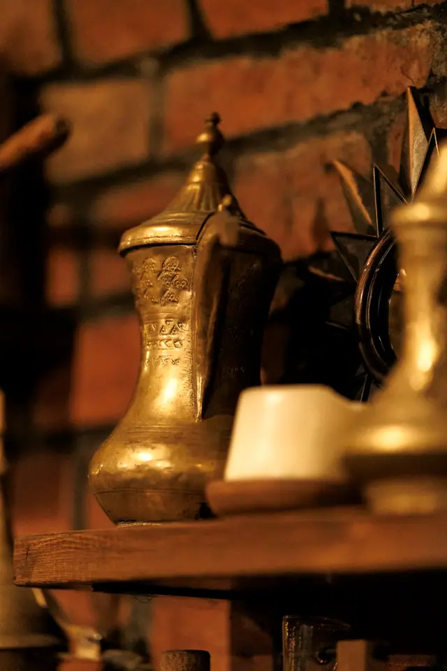 A brass coffee pot softly lit