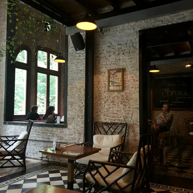 A warm café interior with arched windows and tiled floor